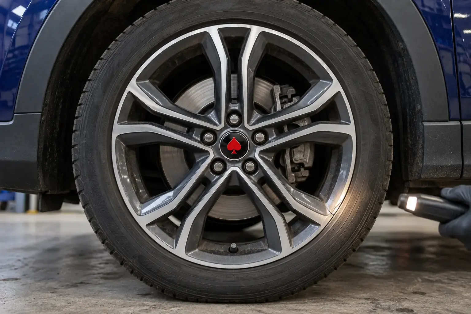 Illustrative gunmetal alloy wheel being inspected for a crack