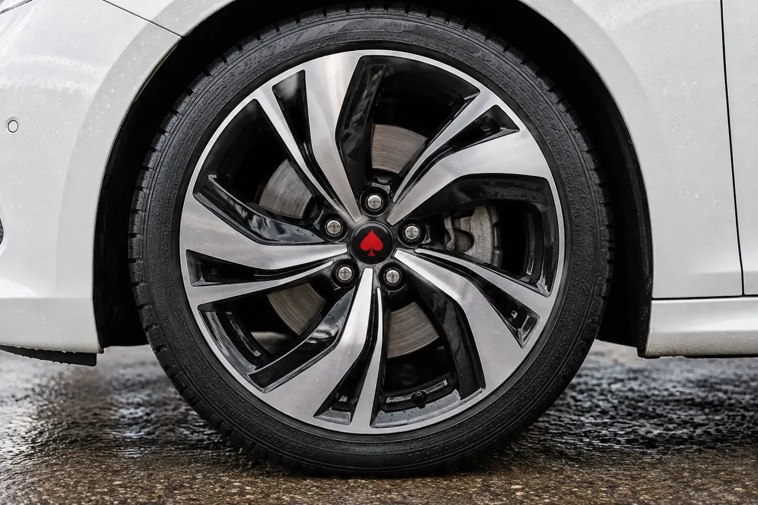 Illustrative black and silver two-tone alloy wheel on a white car